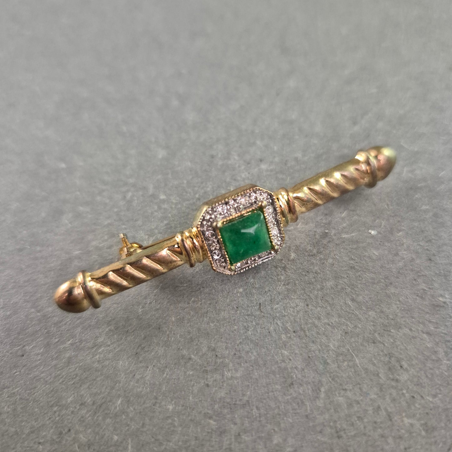 Elegante Vintage-Brosche mit grünem Stein und Zierfassung