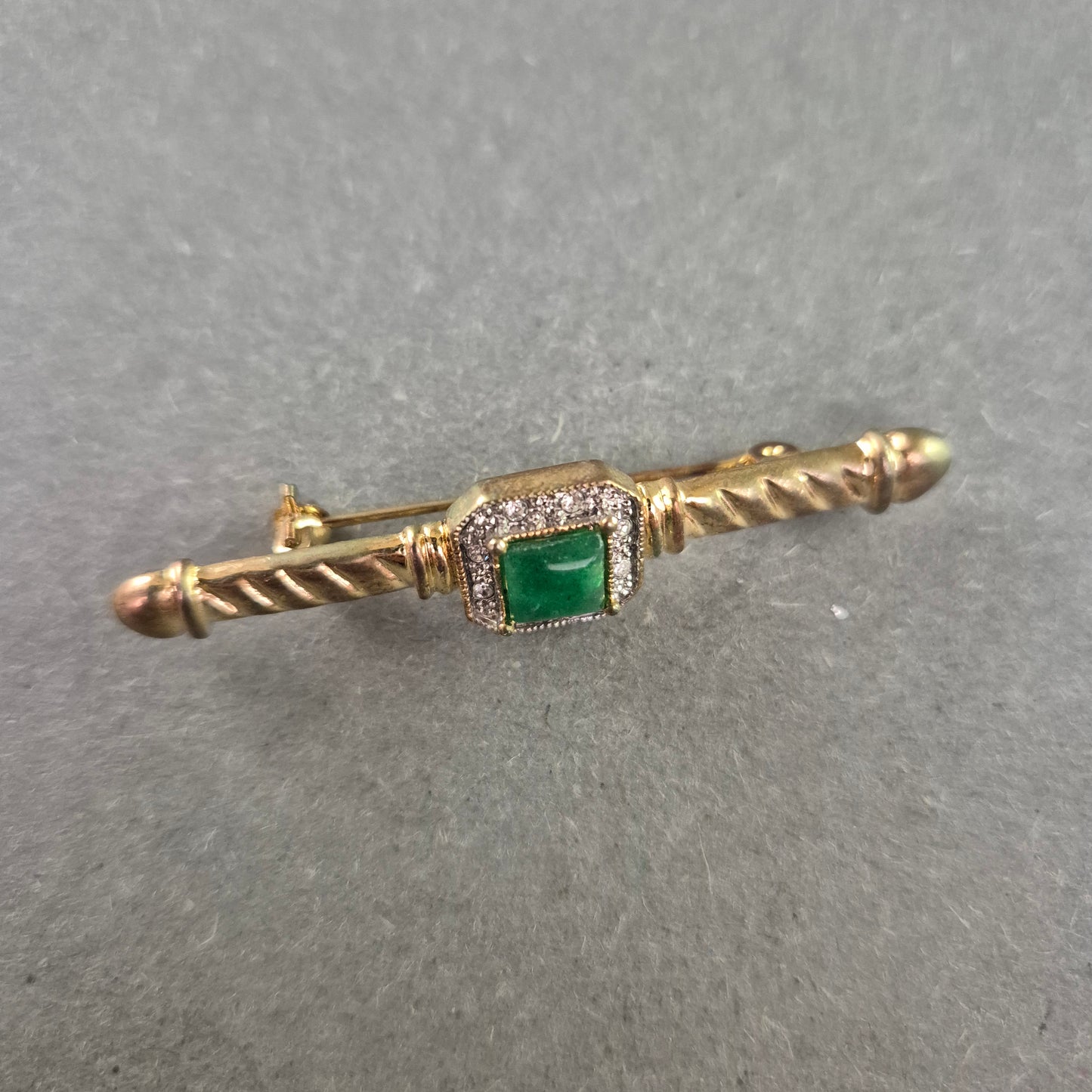 Elegante Vintage-Brosche mit grünem Stein und Zierfassung