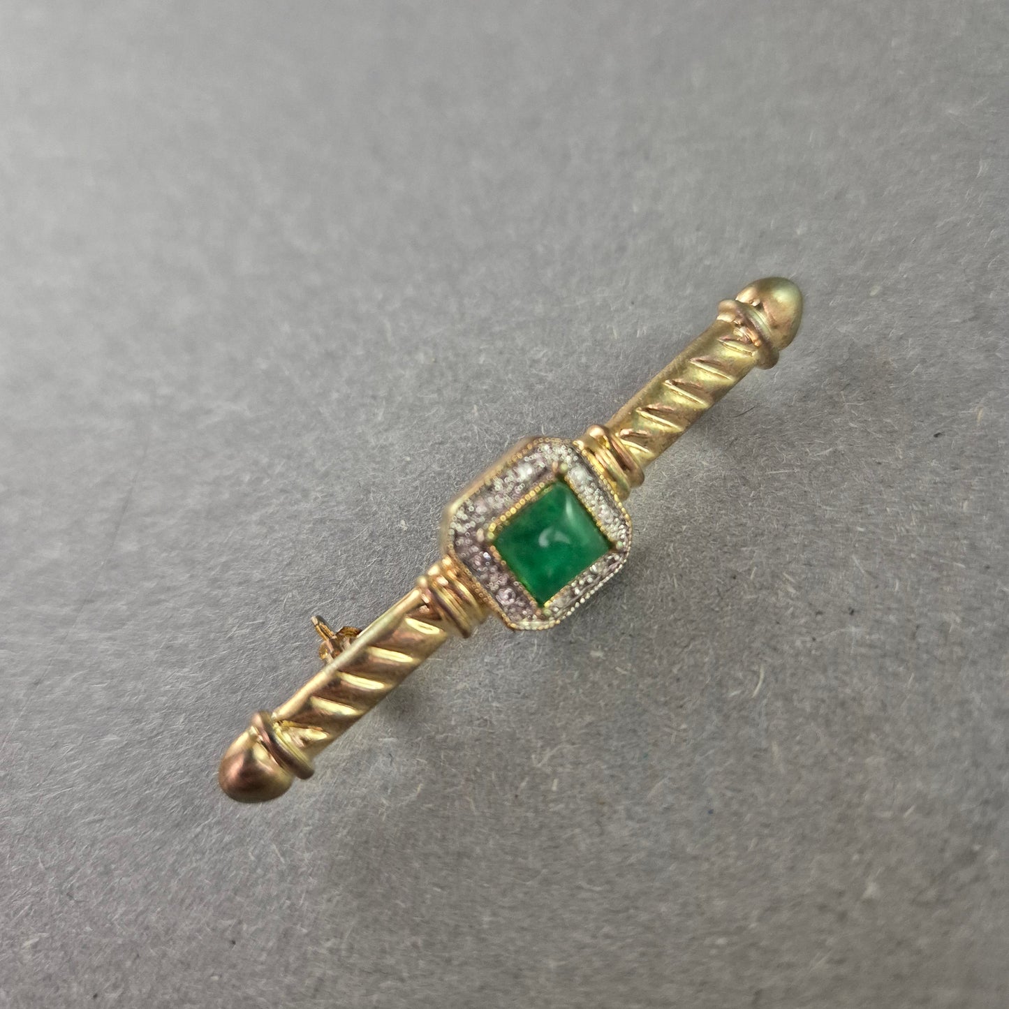 Elegante Vintage-Brosche mit grünem Stein und Zierfassung