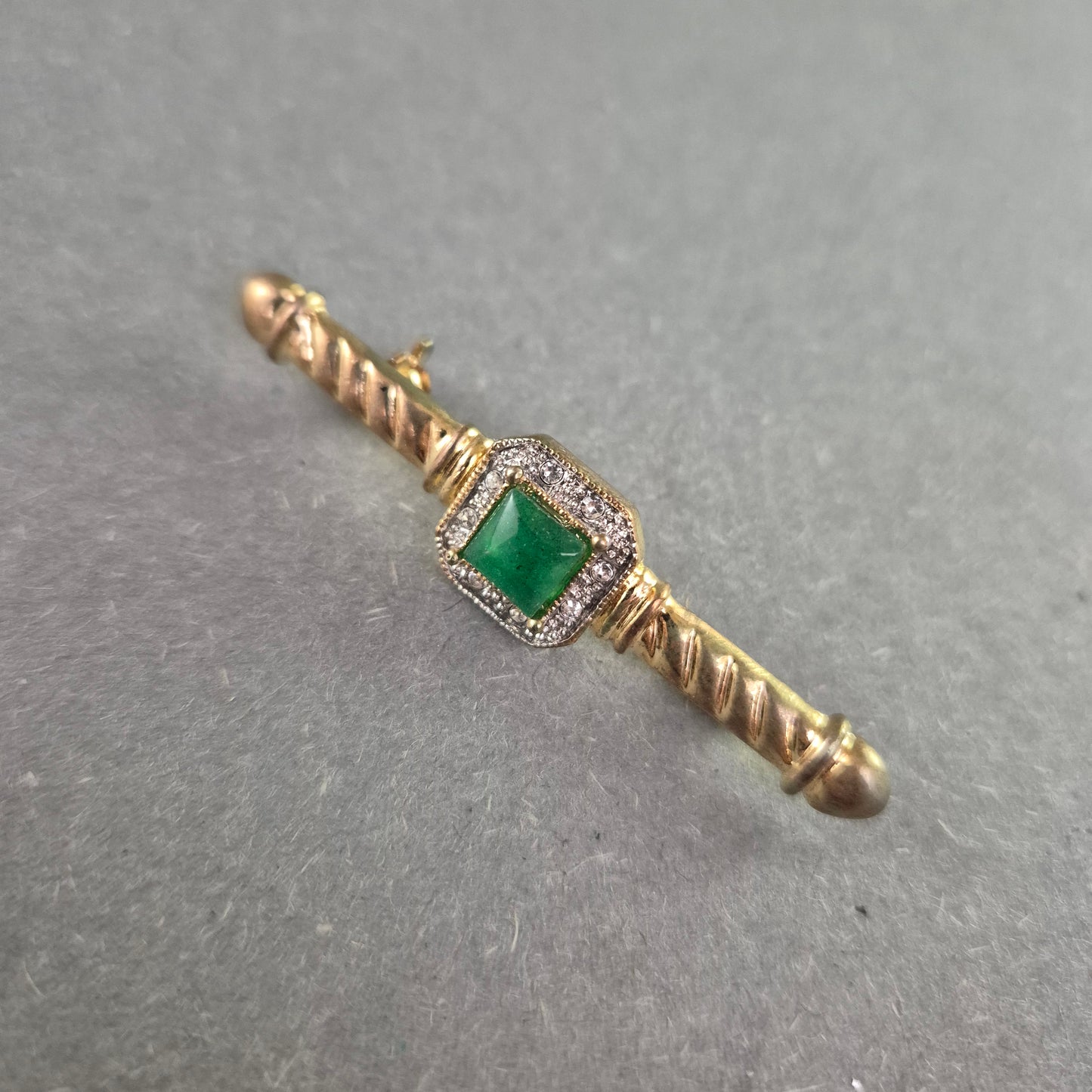 Elegante Vintage-Brosche mit grünem Stein und Zierfassung