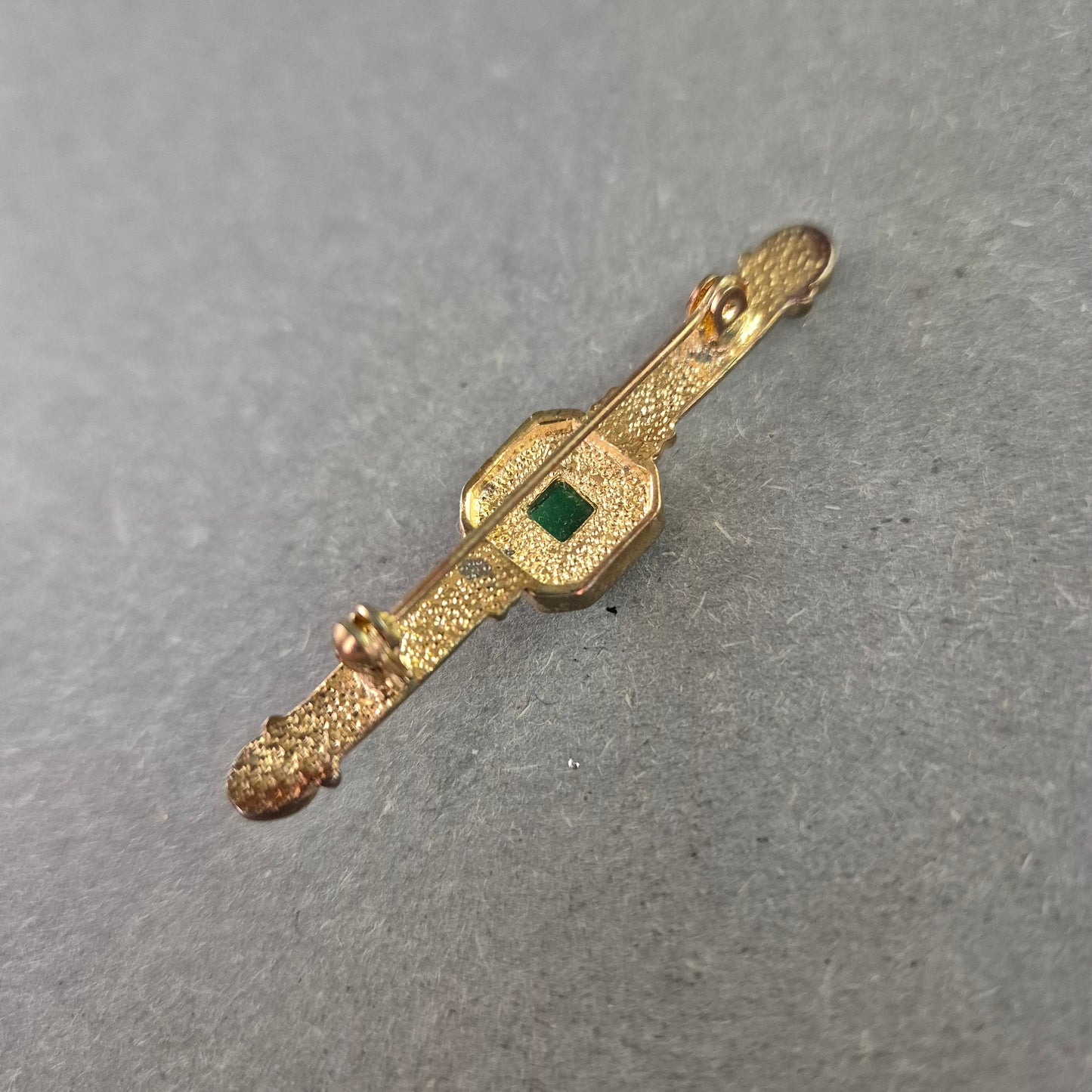 Elegante Vintage-Brosche mit grünem Stein und Zierfassung