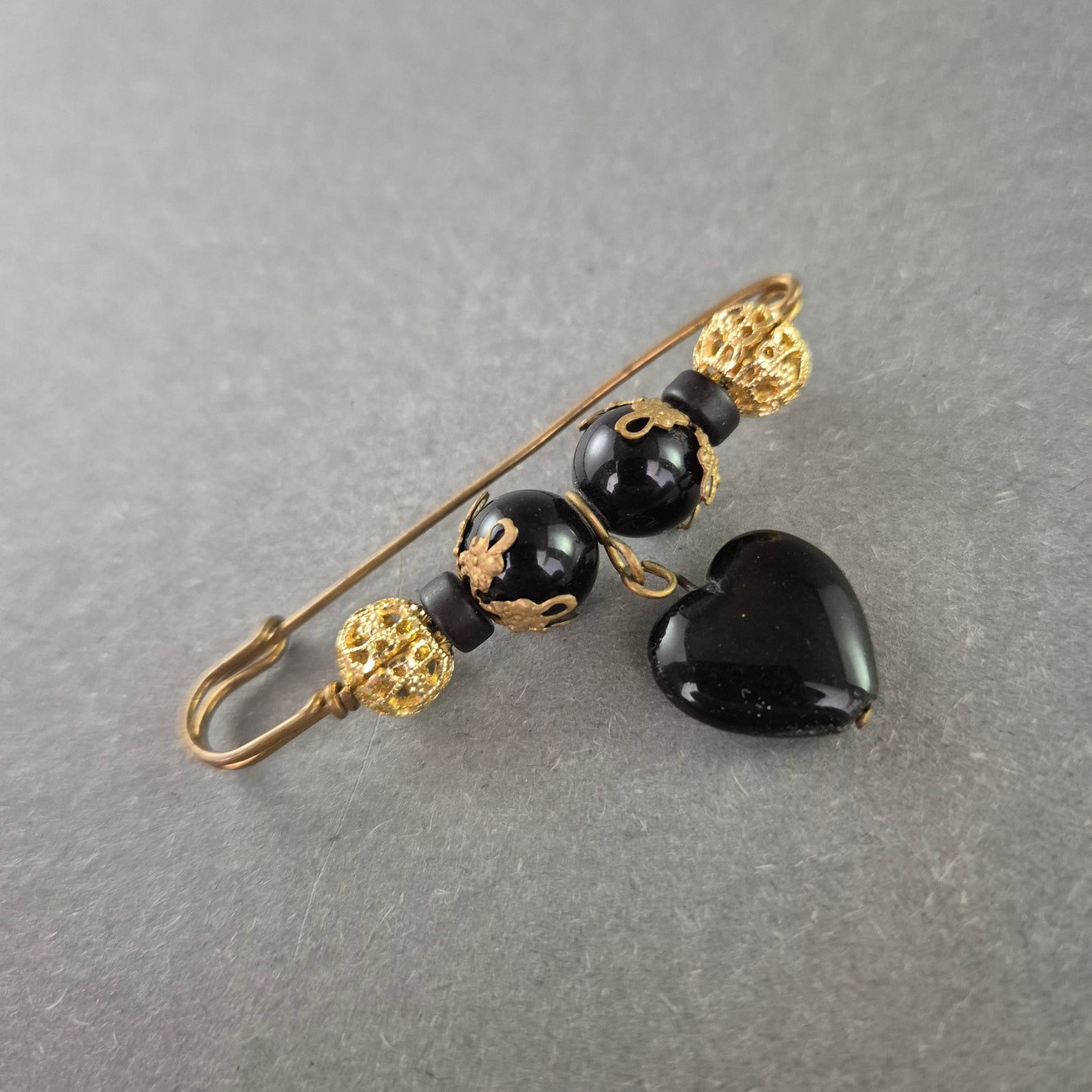 Dekorative Sicherheitsnadel mit schwarzem Herzanhänger – Vintage-Chic