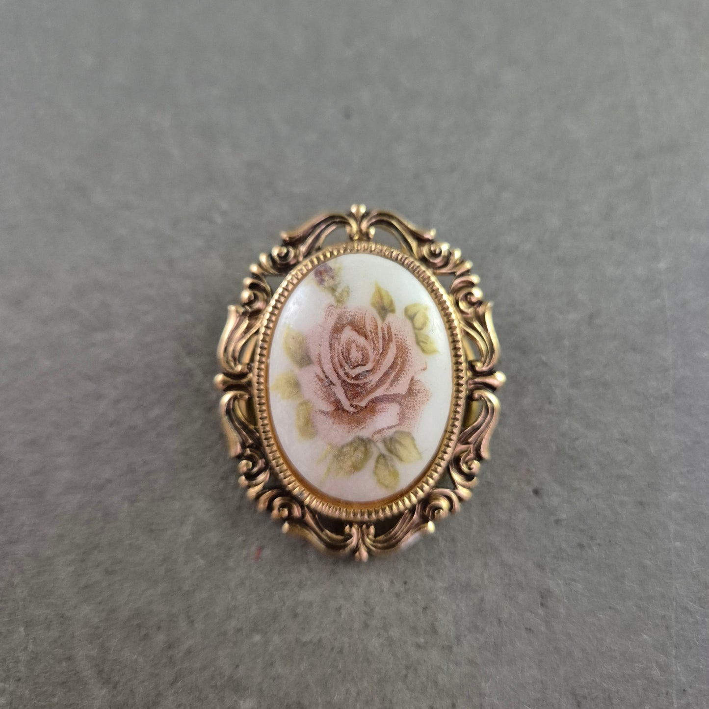 Vintage-Rosenbrosche mit zartem Blütendekor und Goldrahmen