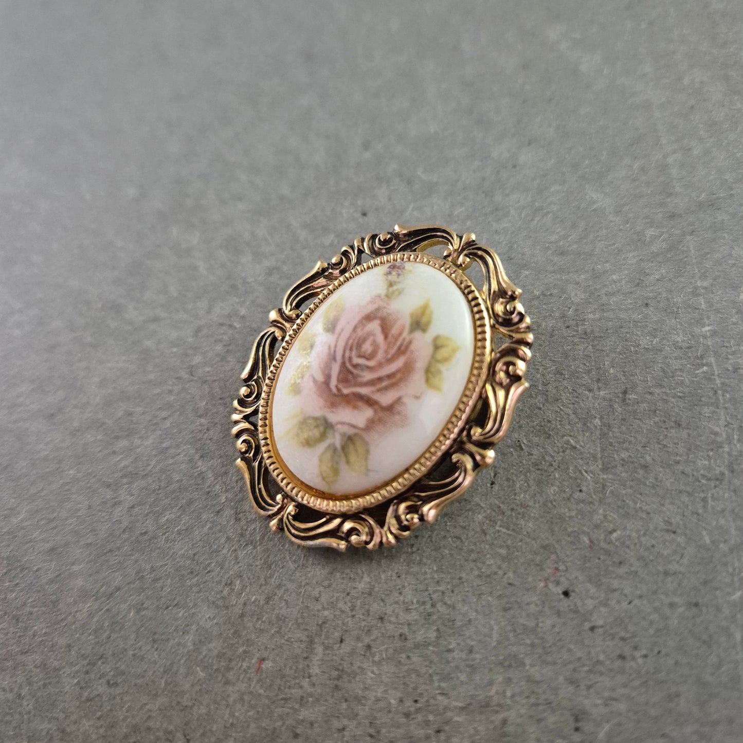 Vintage-Rosenbrosche mit zartem Blütendekor und Goldrahmen