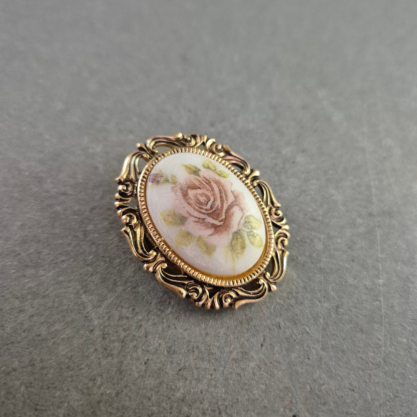 Vintage-Rosenbrosche mit zartem Blütendekor und Goldrahmen