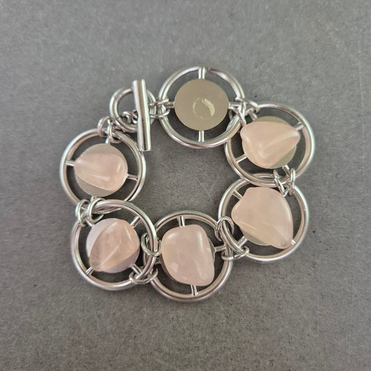 Modernes Armband mit rosa Steinen und runden Metallelementen