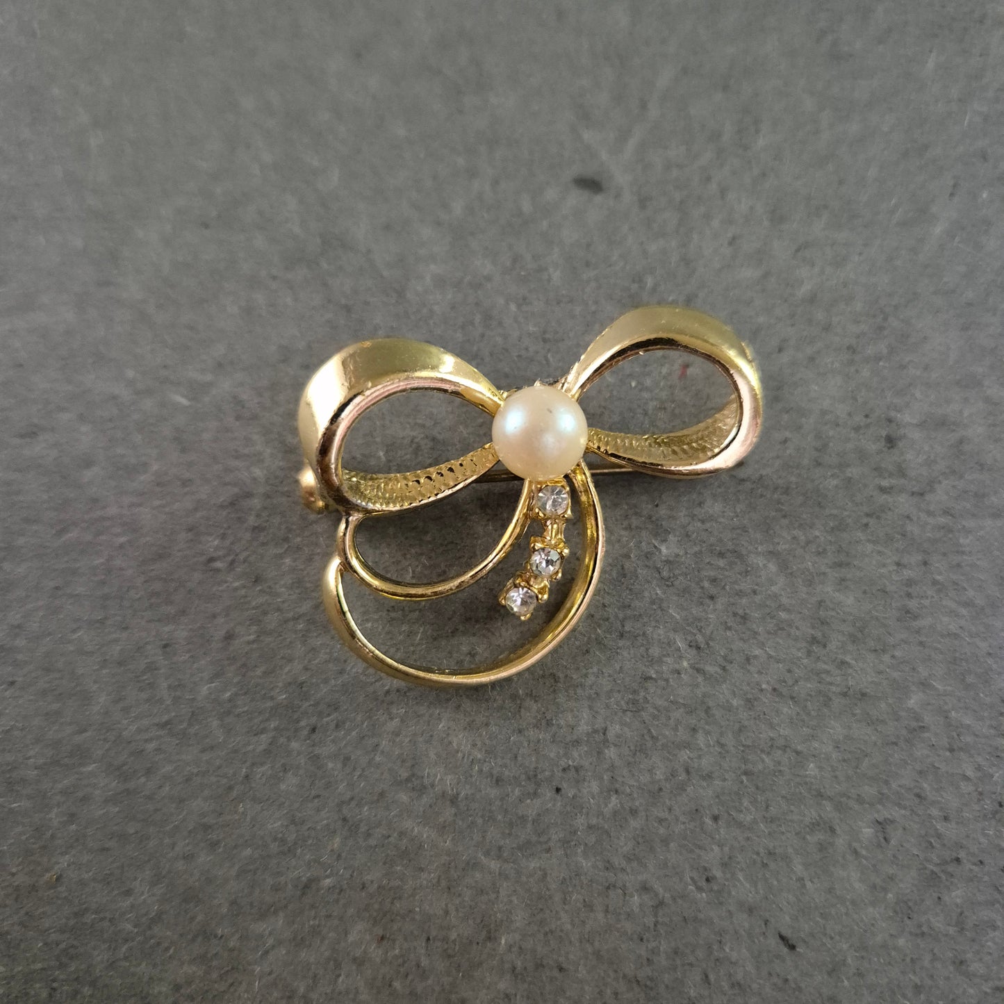 Zarte Brosche in Schleifenform mit Strass und Perlenimitat