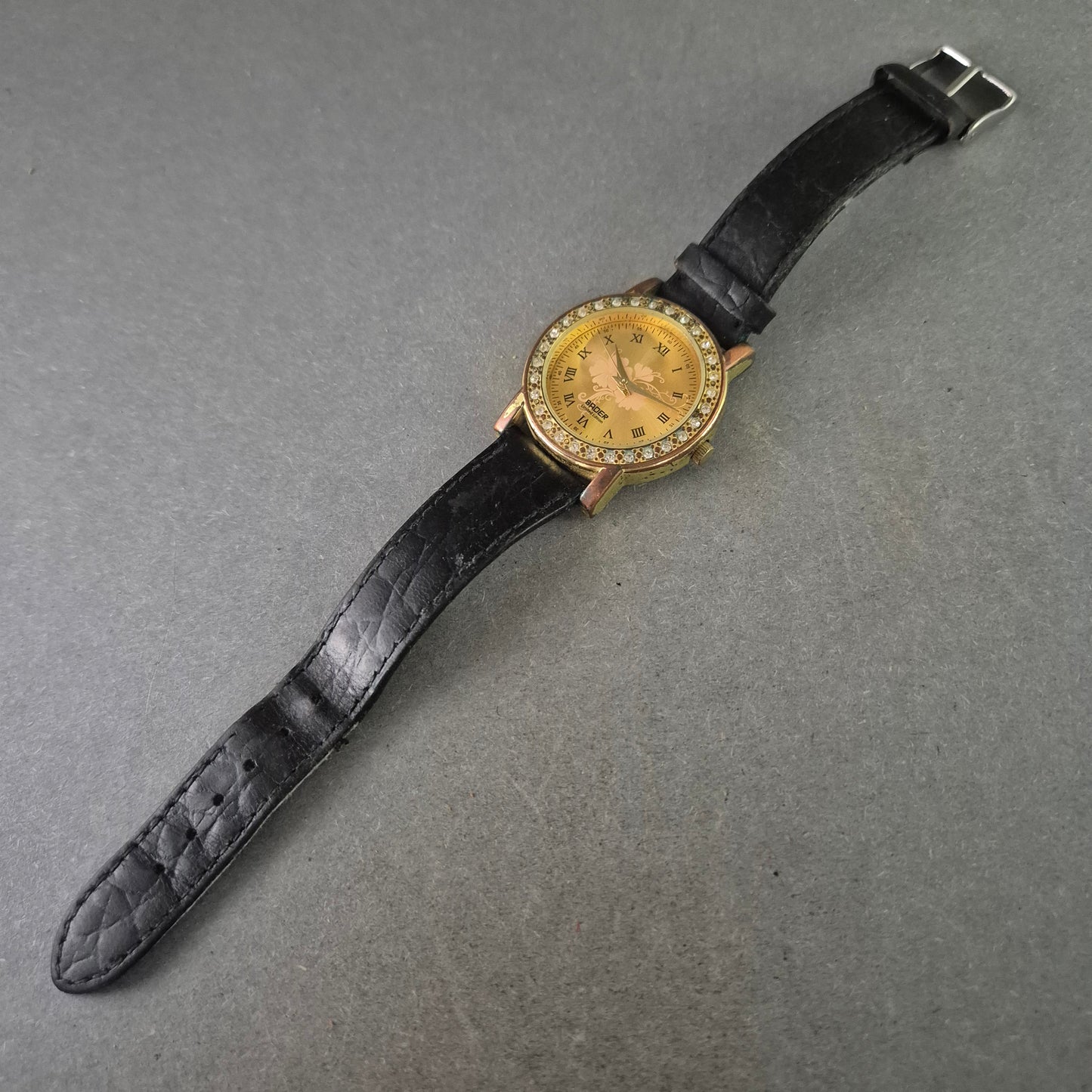 BADER Damenarmbanduhr – Vergoldeter Look mit Strass und Blumenmotiv