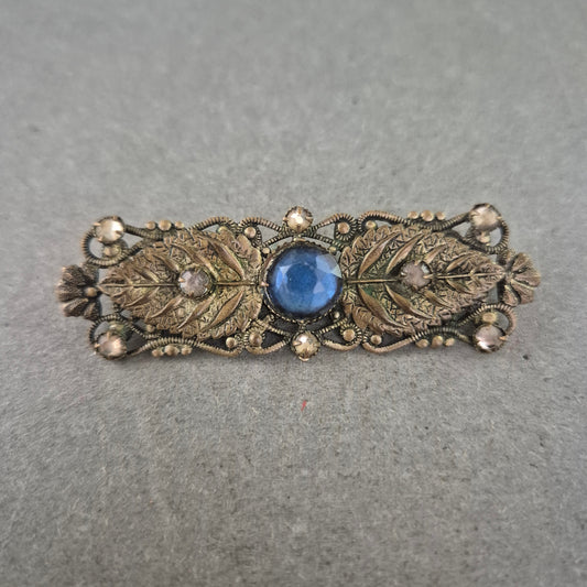 Antike Brosche mit blauem Glasstein und filigraner Blattverzierung
