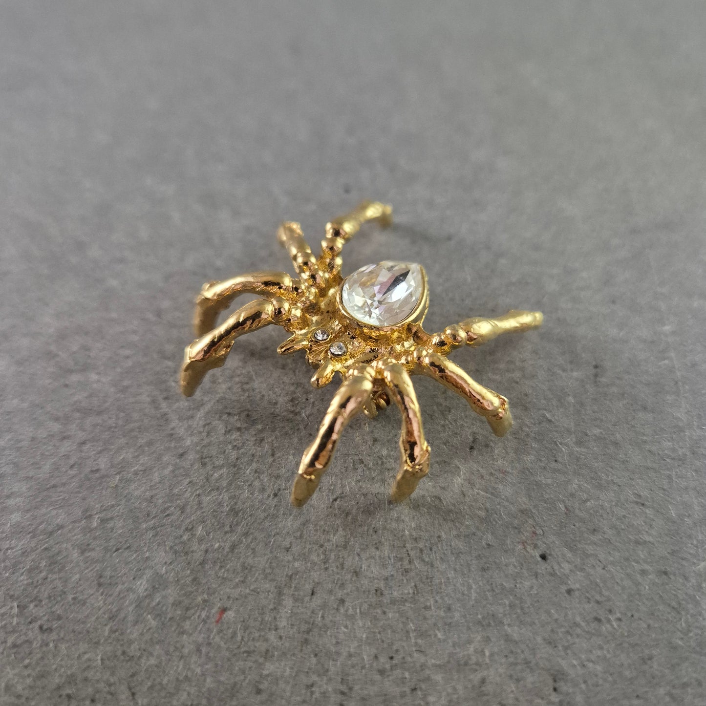 Auffällige Spinnen-Brosche in Goldoptik mit großem Strassstein