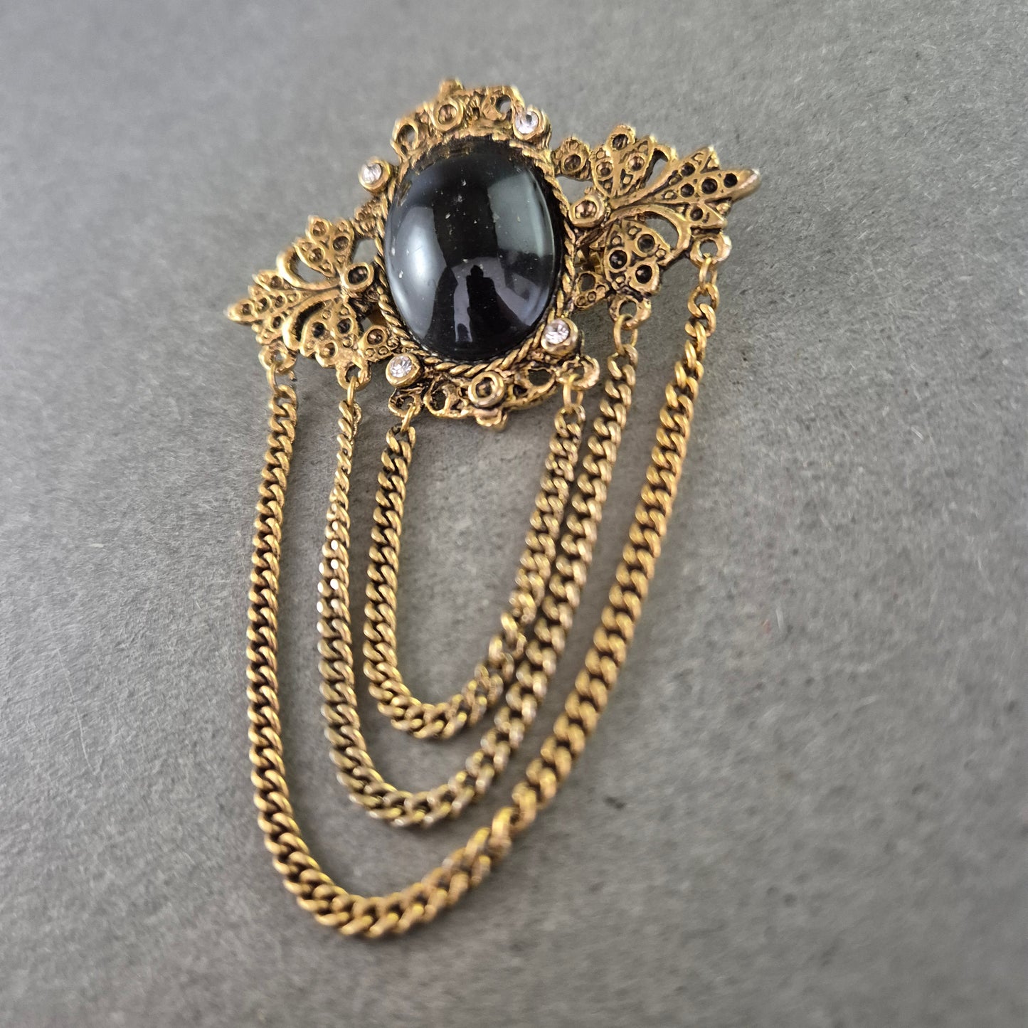 Antike Brosche im Barockstil – Schwarzer Cabochon & Kettendekor