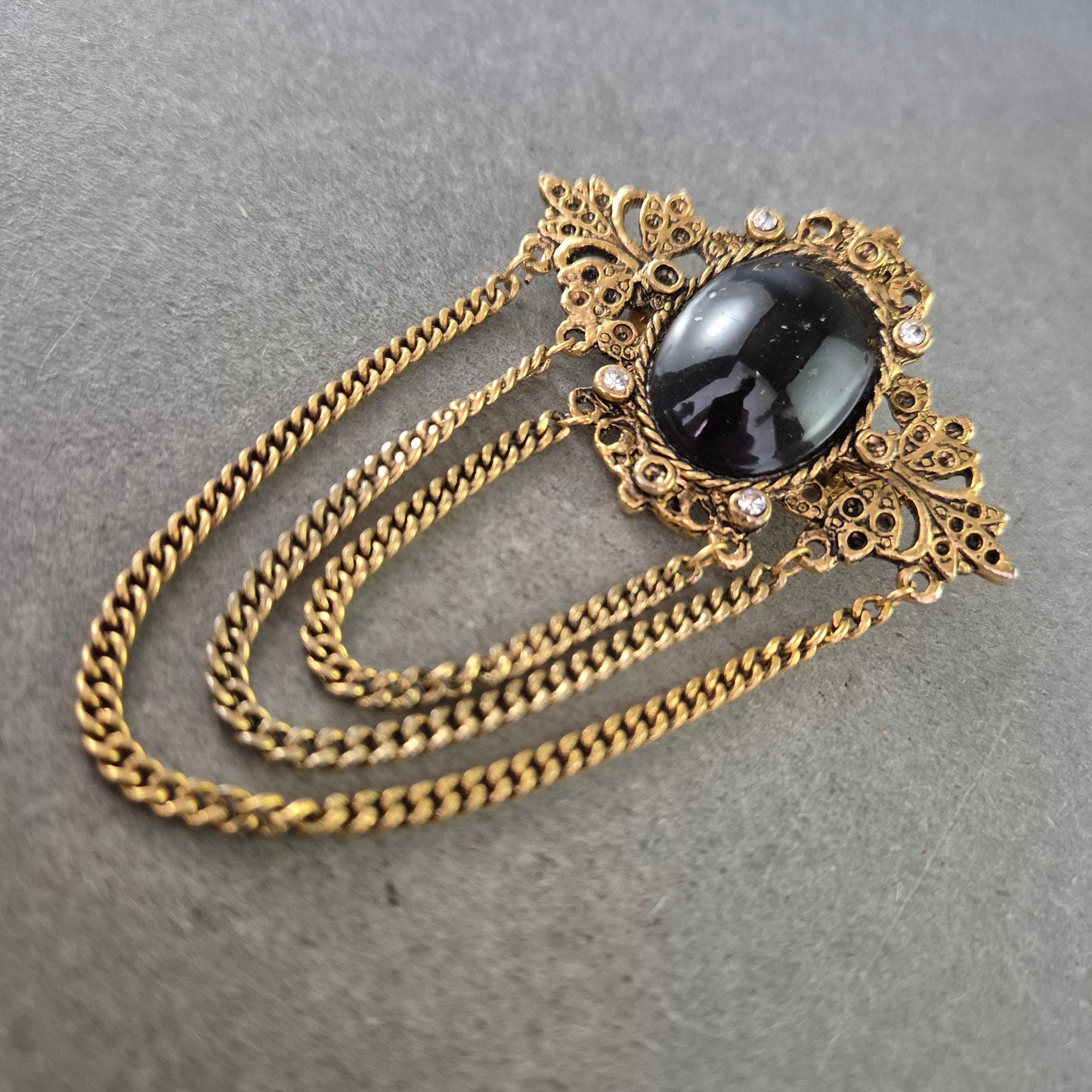 Antike Brosche im Barockstil – Schwarzer Cabochon & Kettendekor