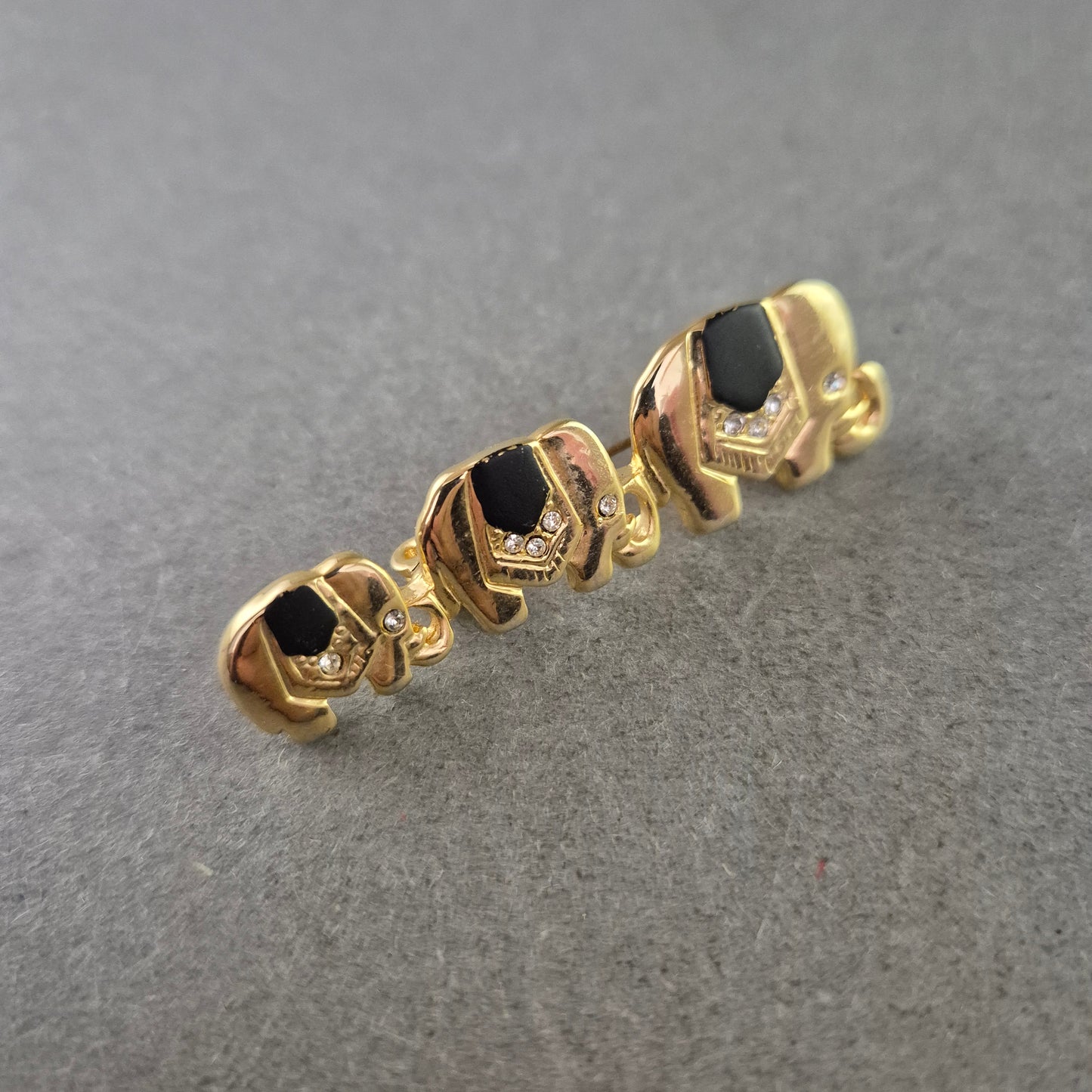 Vintage Brosche Elefantenreihe – Goldfarben, Schwarz & Strass