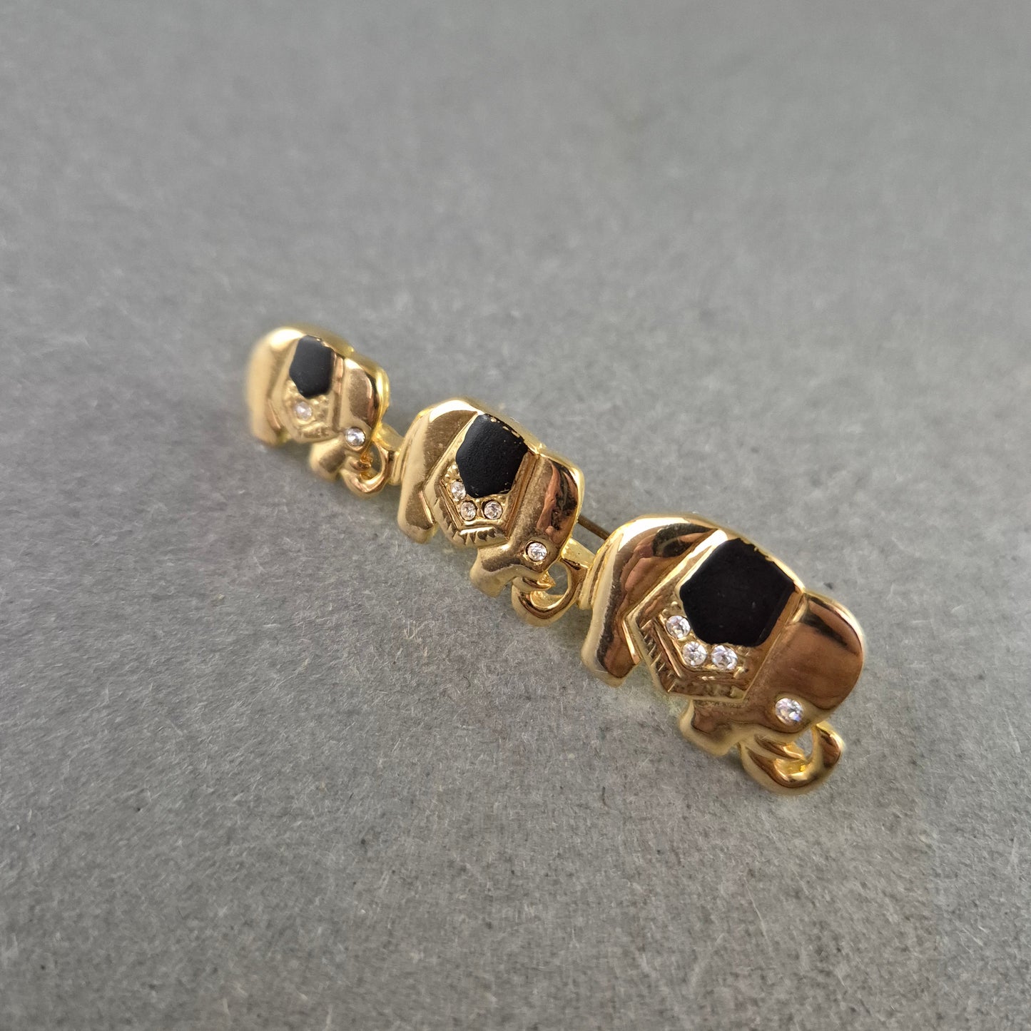 Vintage Brosche Elefantenreihe – Goldfarben, Schwarz & Strass