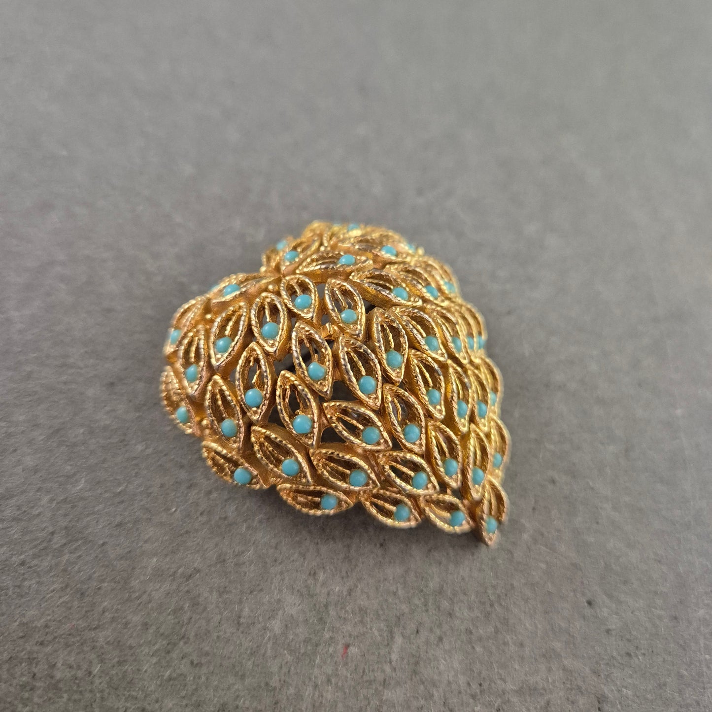 Elegante goldene Brosche mit türkisfarbenen Akzenten – Blattdesign