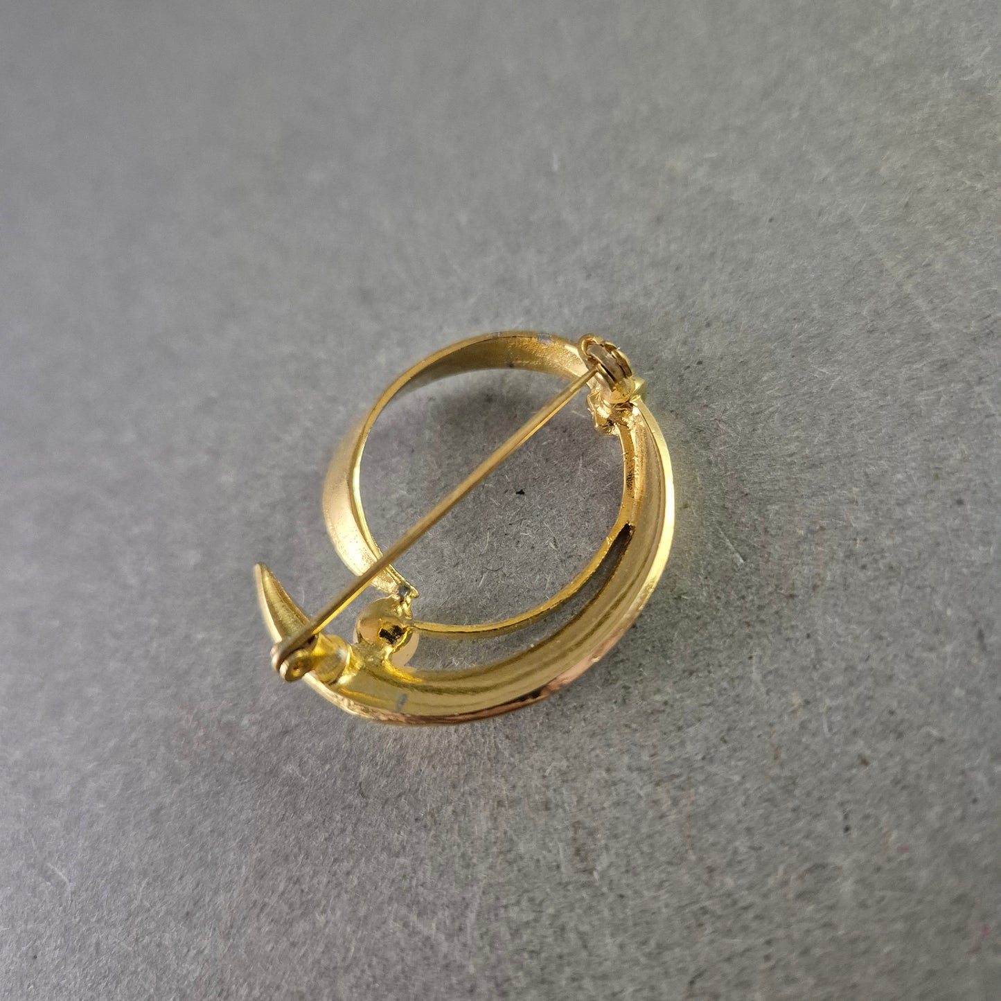 Elegante goldfarbene Brosche mit Perle im modernen Design