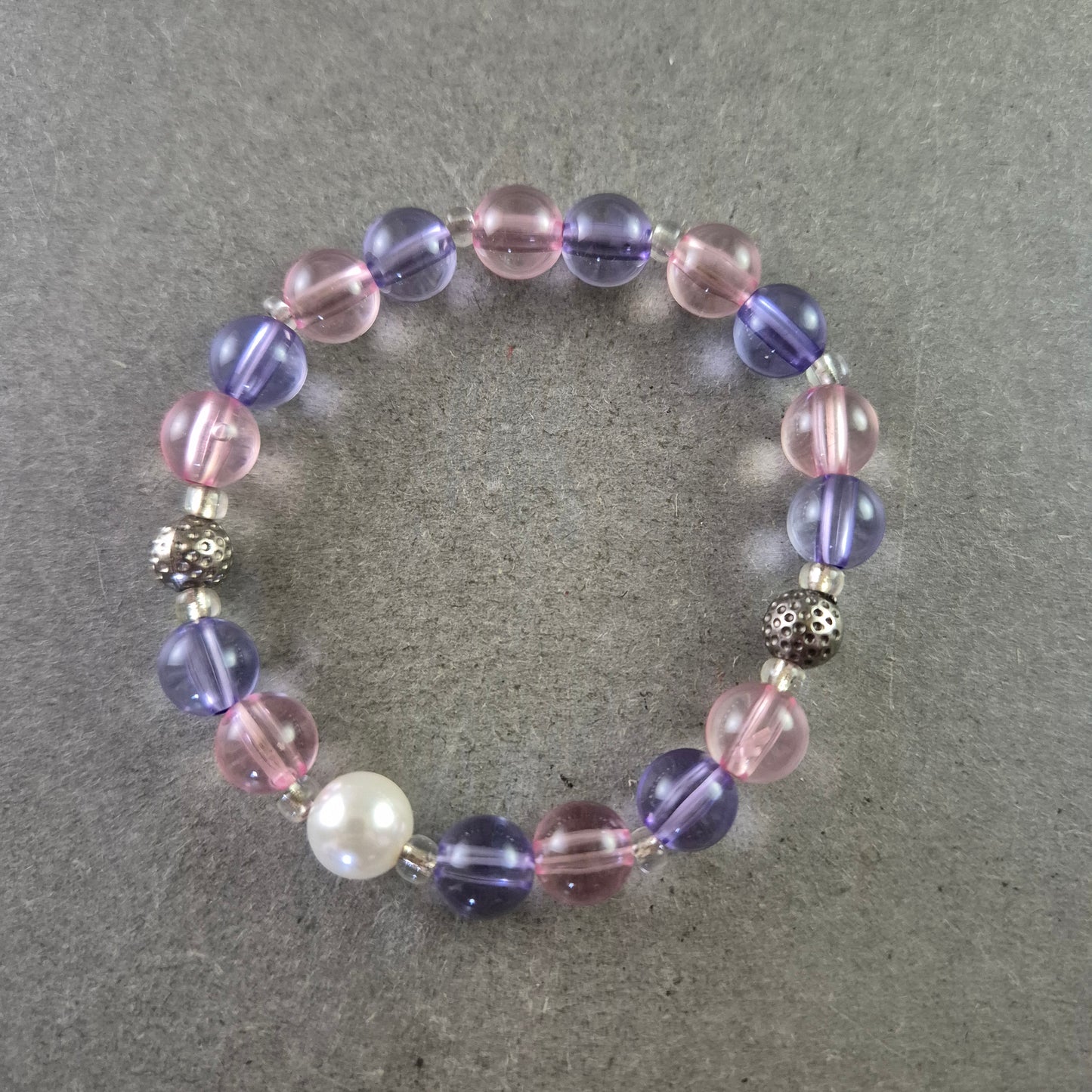 Elastisches Armband mit rosa und violetten Glasperlen