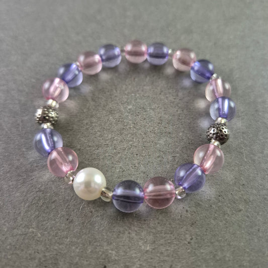 Elastisches Armband mit rosa und violetten Glasperlen