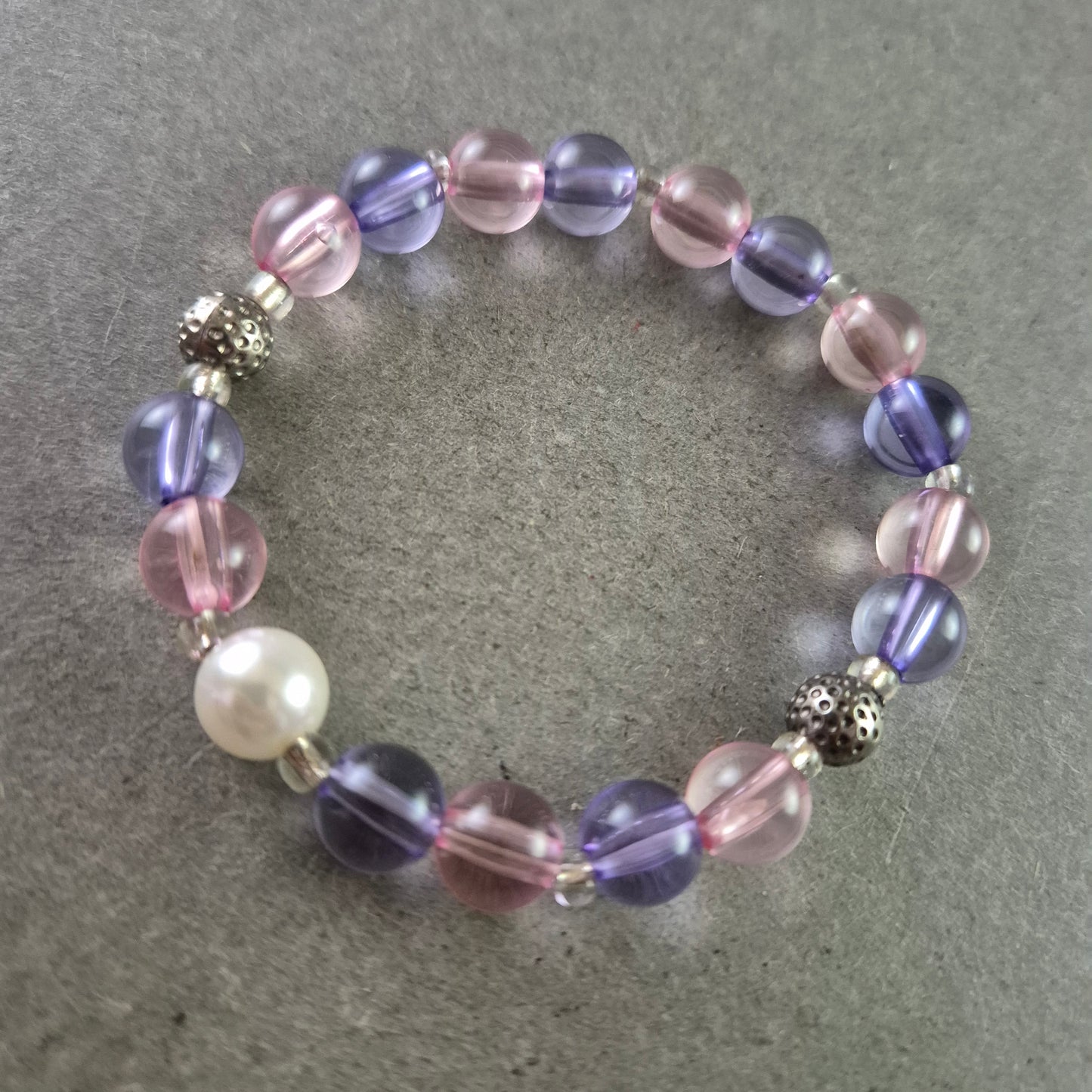 Elastisches Armband mit rosa und violetten Glasperlen