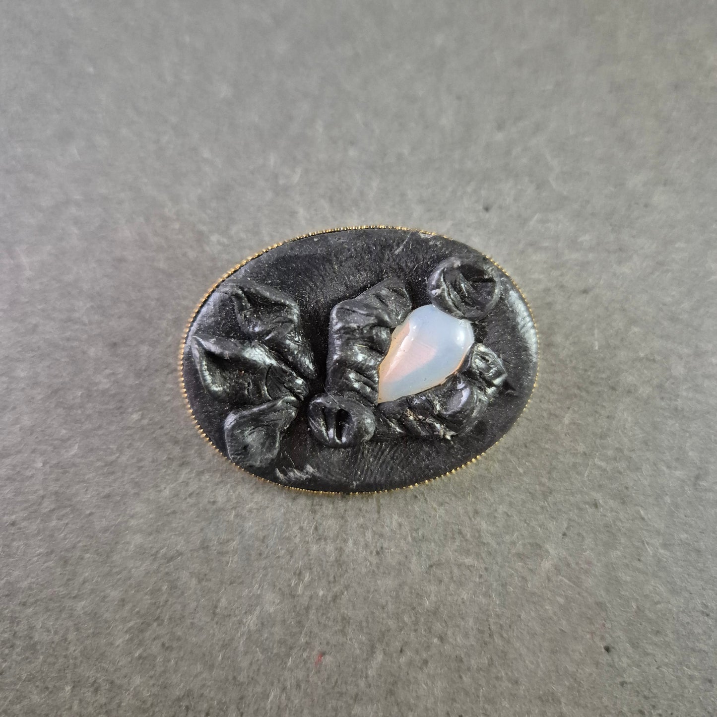 Antike Brosche mit schwarzer Reliefarbeit und Opalglas-Einsatz