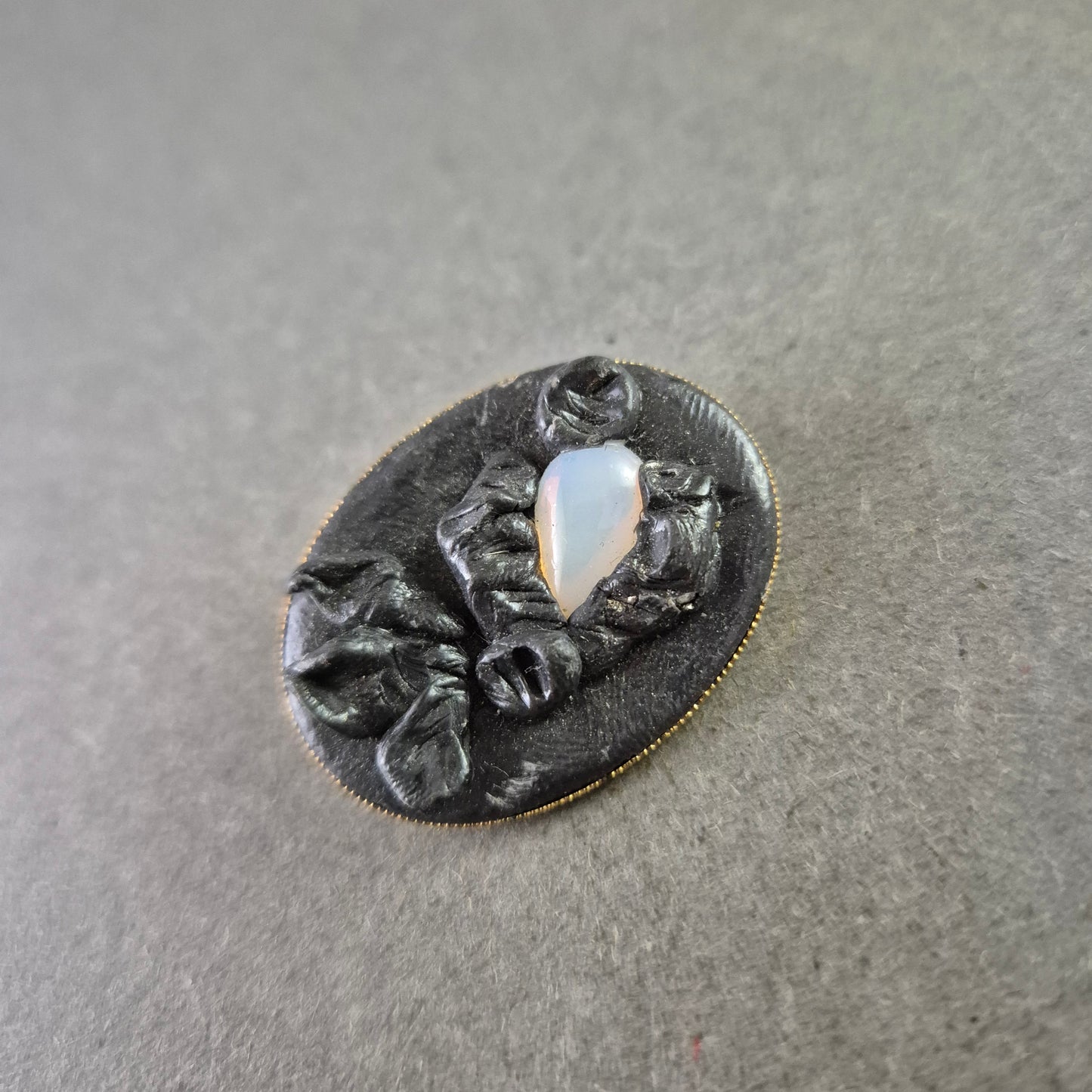 Antike Brosche mit schwarzer Reliefarbeit und Opalglas-Einsatz