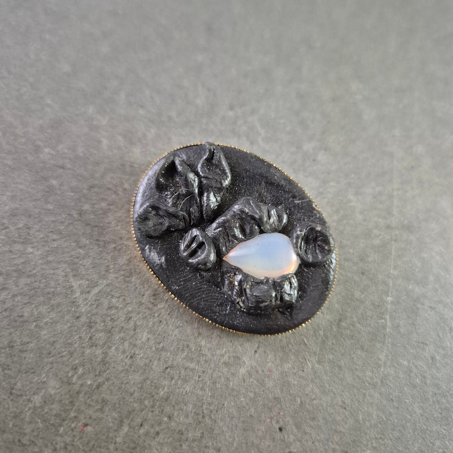 Antike Brosche mit schwarzer Reliefarbeit und Opalglas-Einsatz