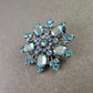 Elegante Brosche mit blauen Strasssteinen – Schneeflocken Design