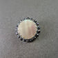 Runde Brosche mit Perlmutt und schwarzer Steinverzierung