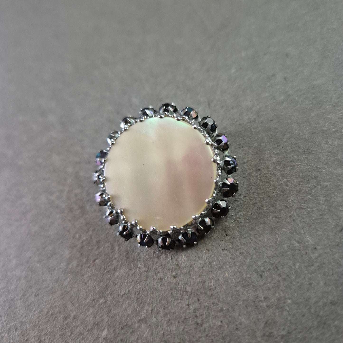Runde Brosche mit Perlmutt und schwarzer Steinverzierung