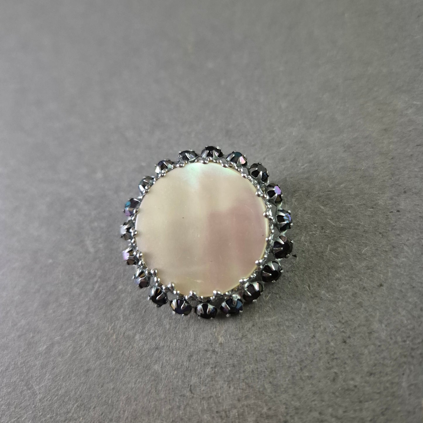 Runde Brosche mit Perlmutt und schwarzer Steinverzierung