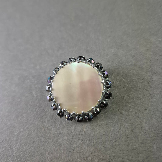 Runde Brosche mit Perlmutt und schwarzer Steinverzierung