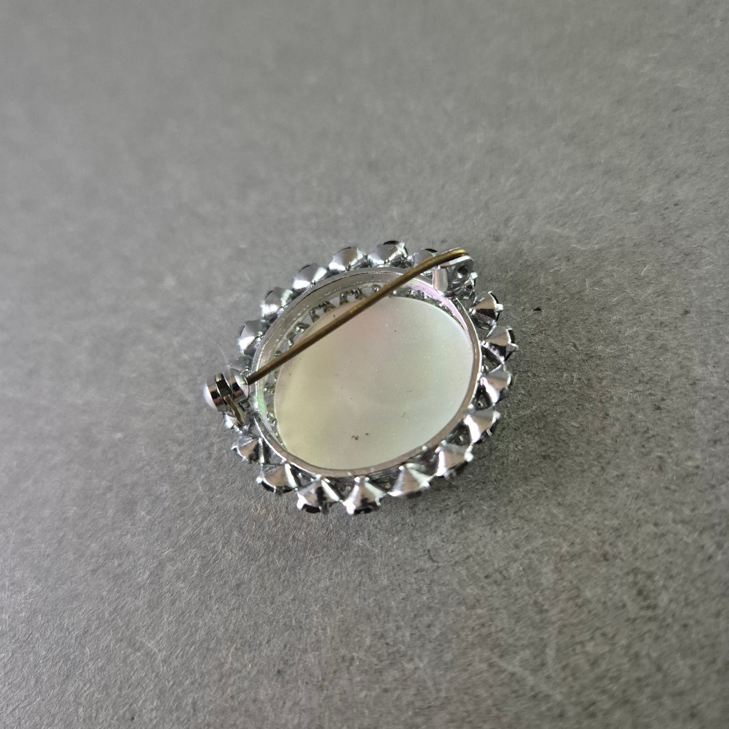 Runde Brosche mit Perlmutt und schwarzer Steinverzierung