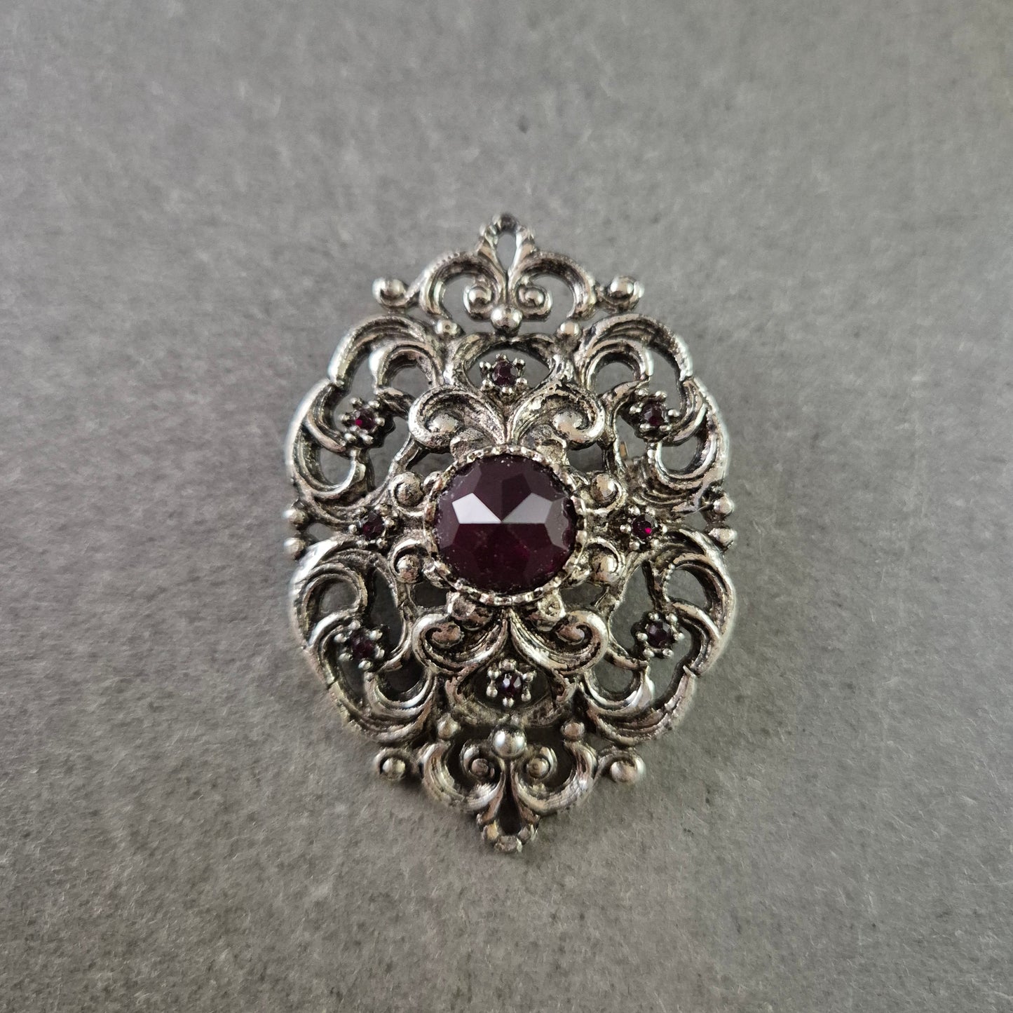 Antike Brosche im Barockstil – Silberfarben mit rotem Schmuckstein
