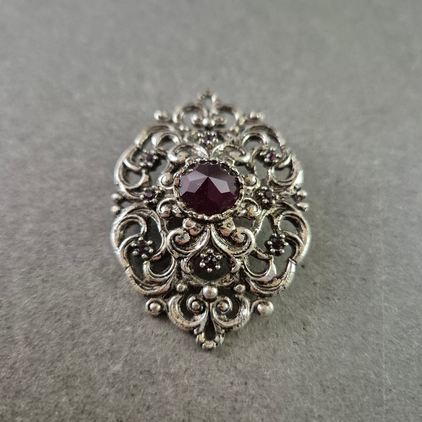 Antike Brosche im Barockstil – Silberfarben mit rotem Schmuckstein