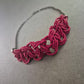Kette mit Macramé-Element in Pink und dunklem Metall