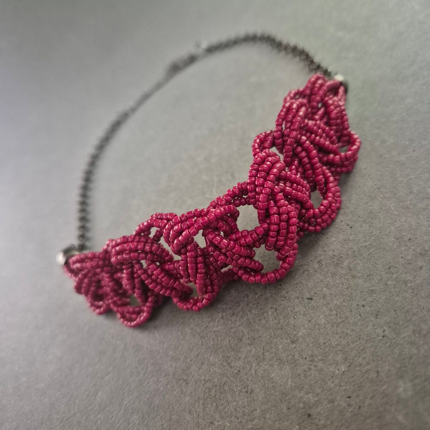 Kette mit Macramé-Element in Pink und dunklem Metall