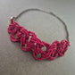 Kette mit Macramé-Element in Pink und dunklem Metall