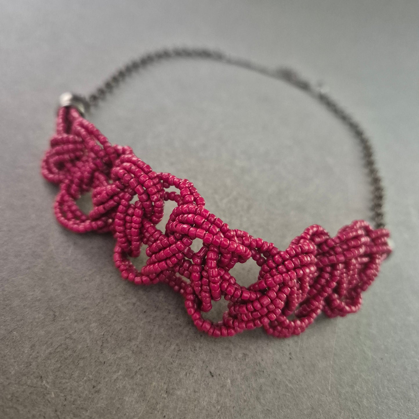 Kette mit Macramé-Element in Pink und dunklem Metall