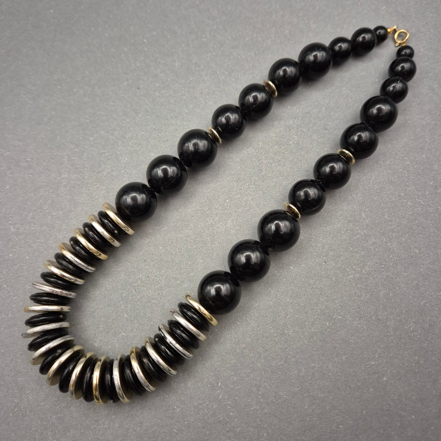 Elegante Halskette mit schwarzen Perlen und Metallscheiben