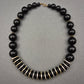 Elegante Halskette mit schwarzen Perlen und Metallscheiben