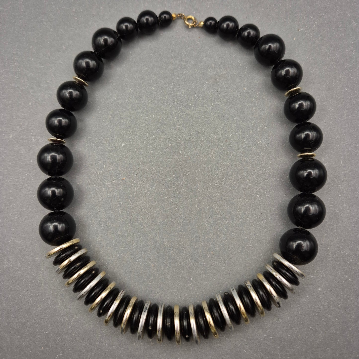 Elegante Halskette mit schwarzen Perlen und Metallscheiben