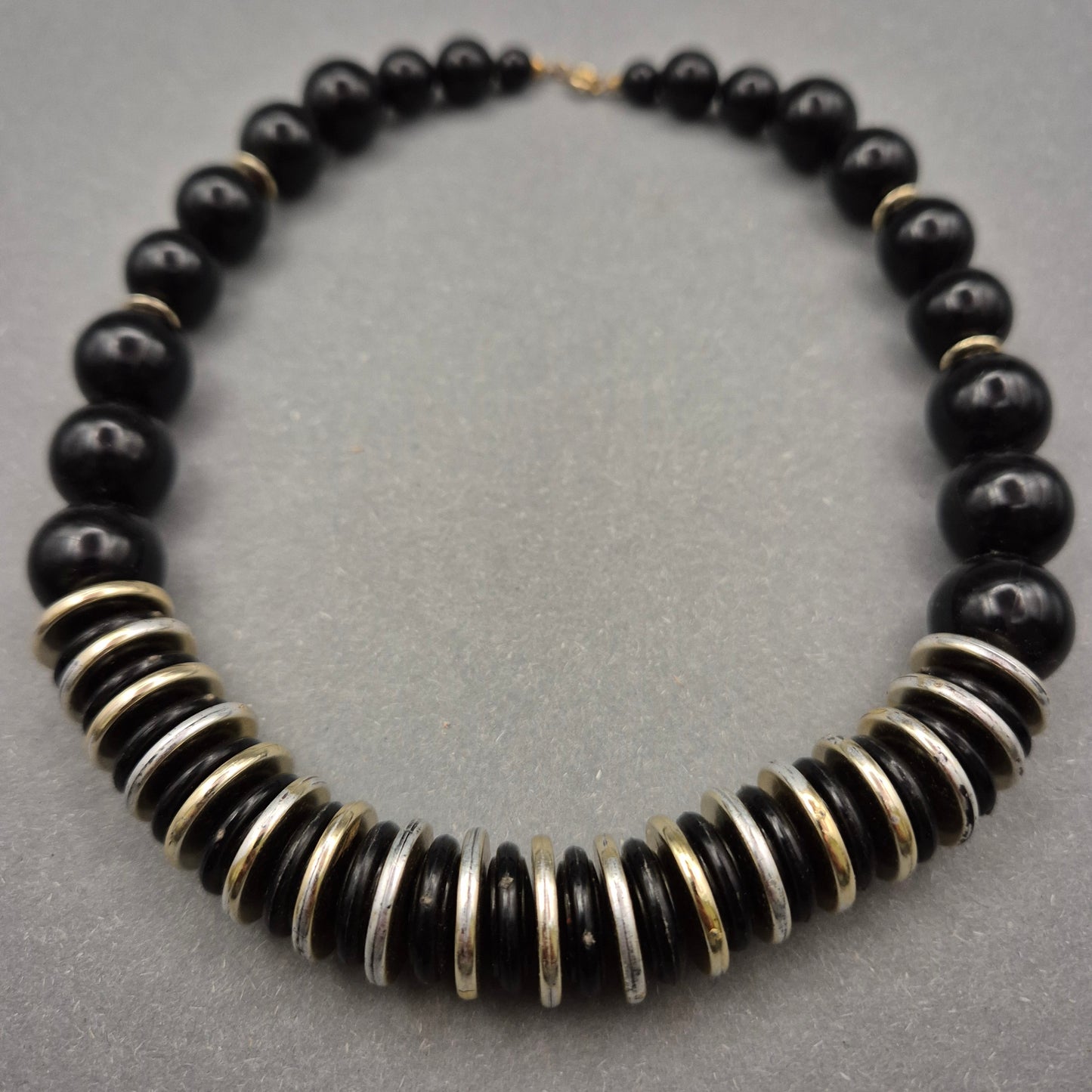 Elegante Halskette mit schwarzen Perlen und Metallscheiben