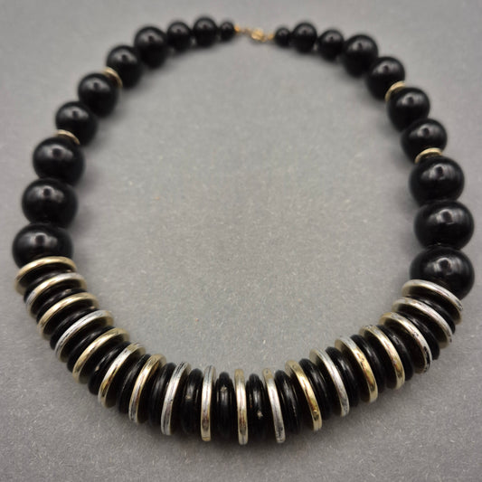 Elegante Halskette mit schwarzen Perlen und Metallscheiben
