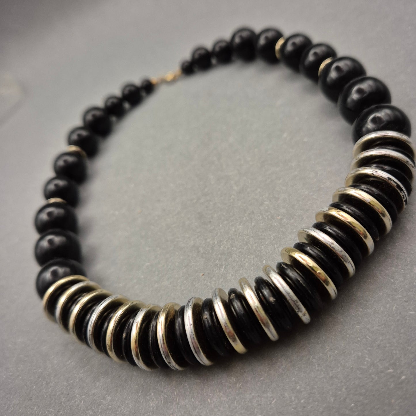 Elegante Halskette mit schwarzen Perlen und Metallscheiben