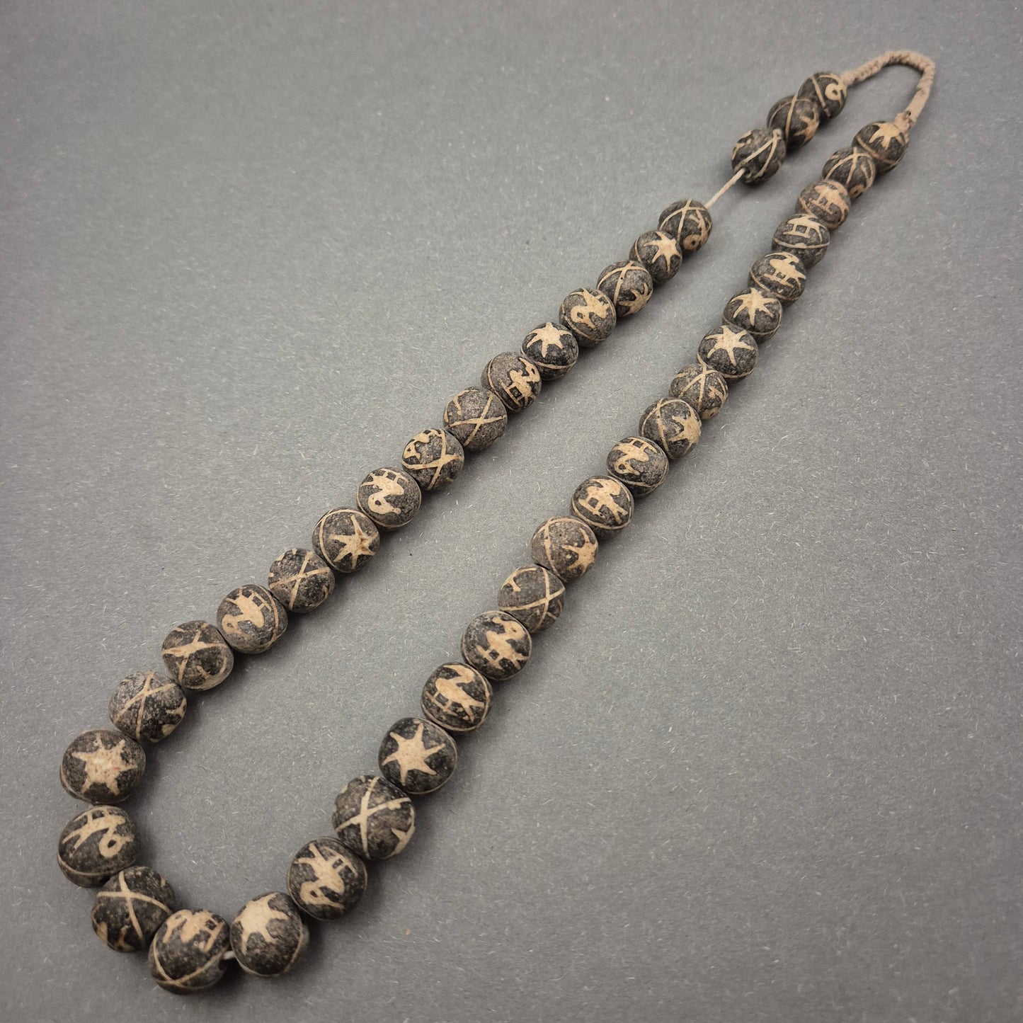 Ethno Halskette mit geschnitzten Symbolperlen in Schwarz-Beige