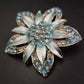Vintage Brosche in Blumenform mit blauen Strasssteinen