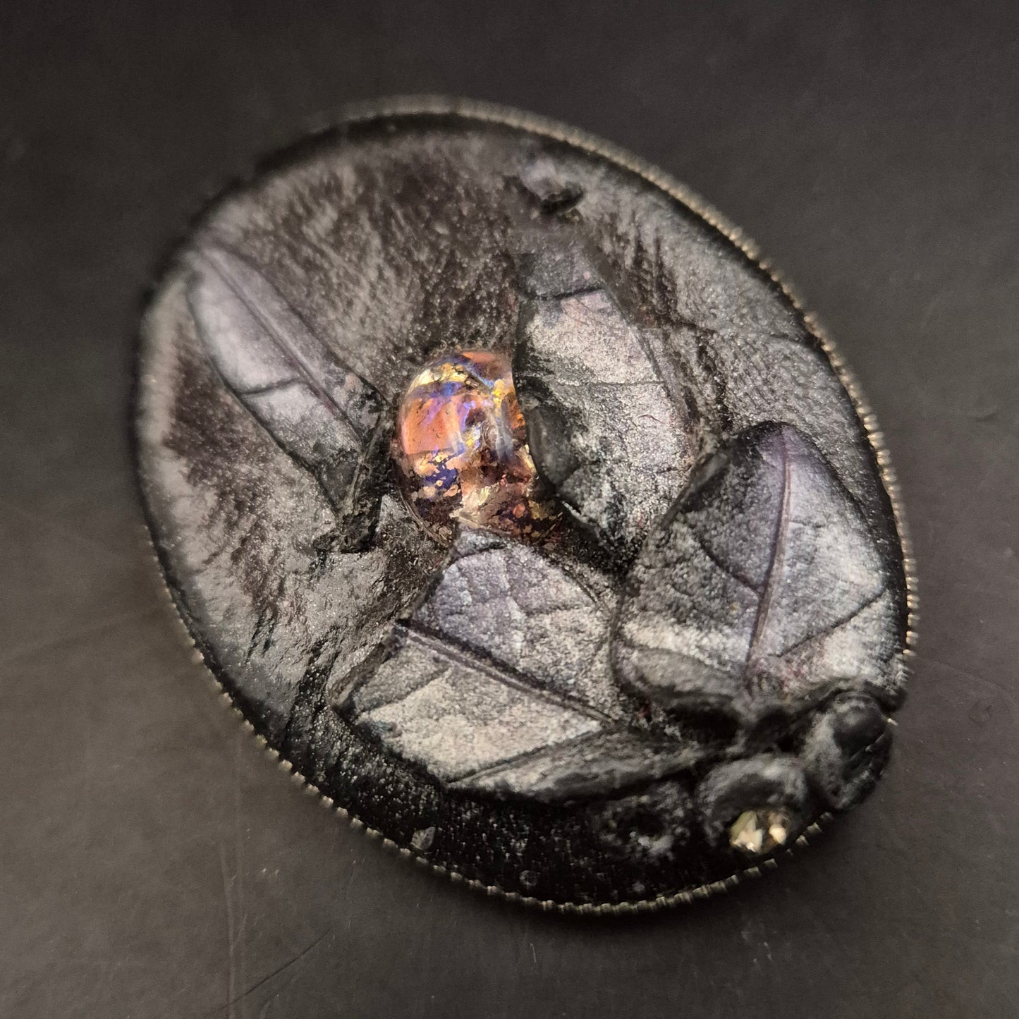 Elegante Brosche aus schwarzem Leder mit leuchtendem Cabochon