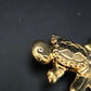 Verspielte Schildkröte auf Skateboard – Goldfarbene Brosche mit Kristall-Auge
