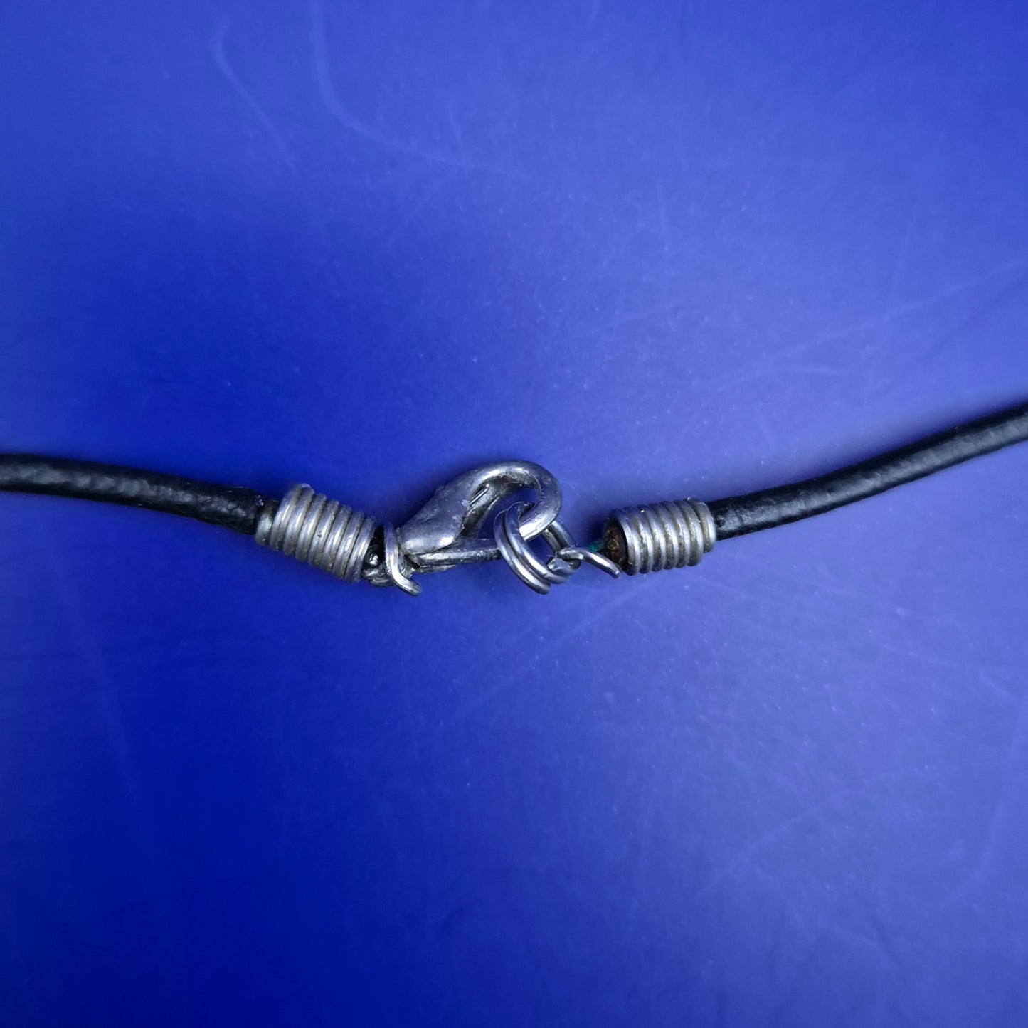 Auffälliger Tropfen-Anhänger mit Glitzer und Silberstreifen an schwarzer Kordel