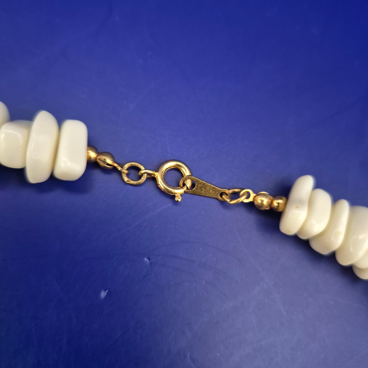 Elegante Statement Halskette mit weißen Steinperlen & Goldakzenten